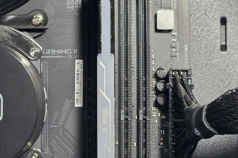 A desktop motherboard with one memory module installed and two empty DIMM slots beside it