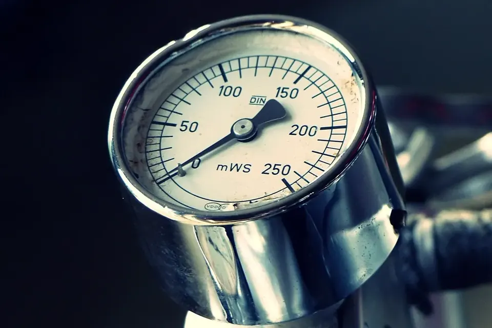 Close-up of a chrome pressure gauge with a needle on a white dial