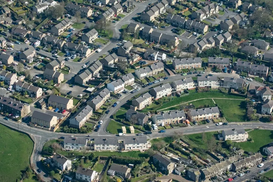 Aerial view of a residential district with terraced houses, curving streets and parked cars