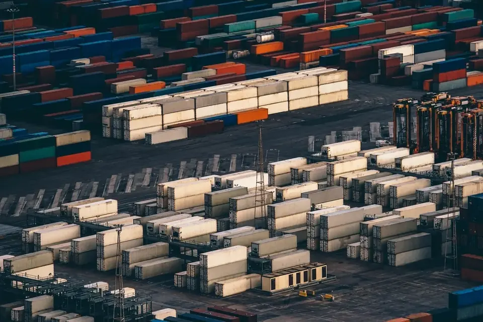 Aerial view of a port terminal with rows of stacked shipping containers