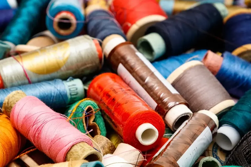 A heap of colourful sewing thread spools